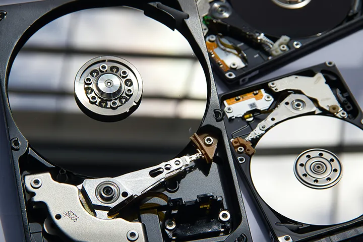 Vue macro d’un disque dur ouvert avec les plateaux et la tête de lecture en gros plan – exemple de panne mécanique analysée par AxonRecup.